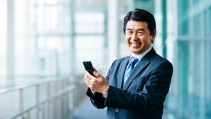 法人スマートフォンを使って仕事をしているビジネスマン